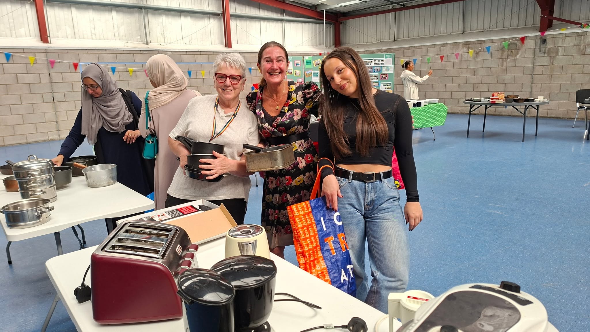 group of people smiling, with cooking equipment