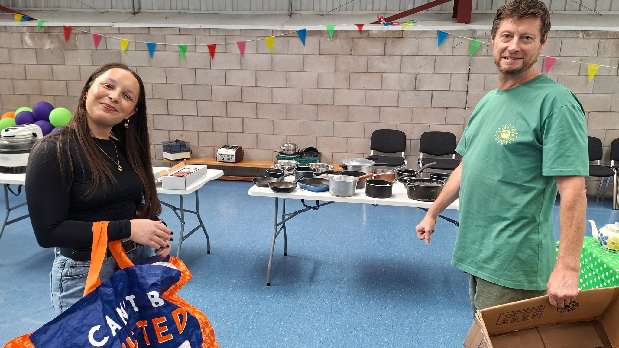 two people smiling with cooking equipment
