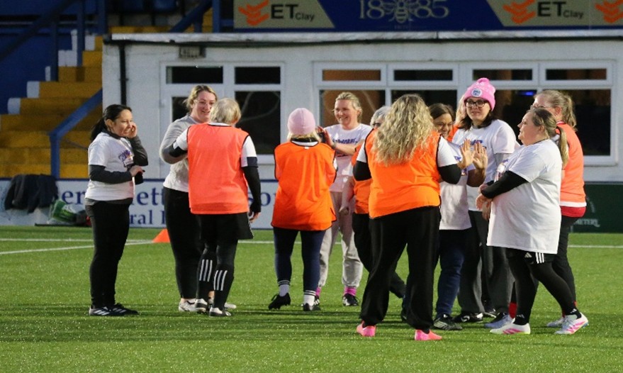 Photograph of a group of women smiling and celebrating a sports achievement.