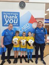 Radcliffe Juniors stood near a Tesco sign doing their bucket collection