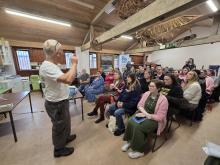 Image of a man presenting to a group of people watching on