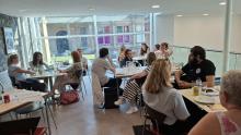 Group photo of people sitting around tables in a cafe