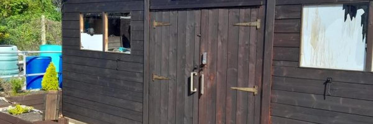 A photo of a brown shed at the allotments on a sunny day