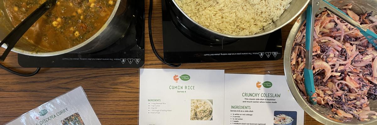 Picture of a hearty lentil curry, rice and coleslaw with recipe cards