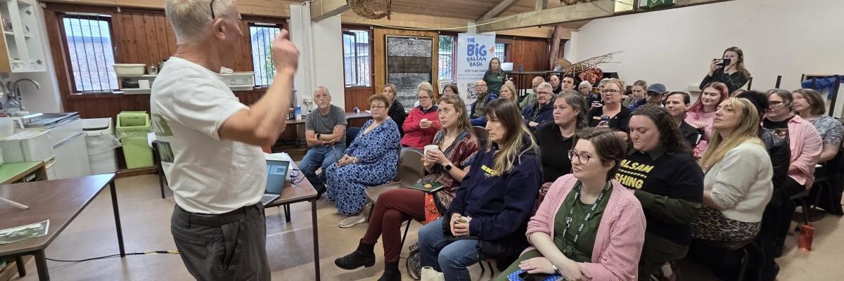 Image of a man presenting to a group of people watching on