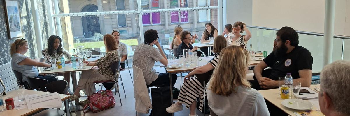 Group photo of people sitting around tables in a cafe