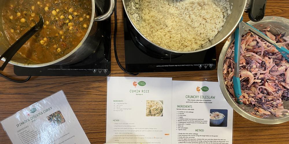 Picture of a hearty lentil curry, rice and coleslaw with recipe cards