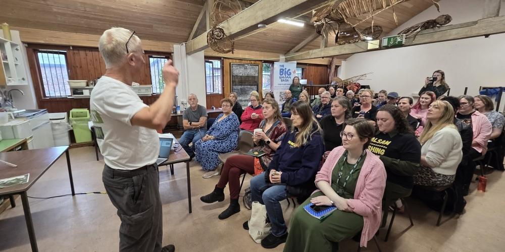 Image of a man presenting to a group of people watching on