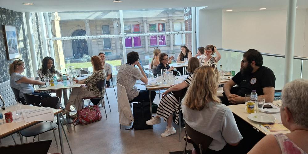 Group photo of people sitting around tables in a cafe